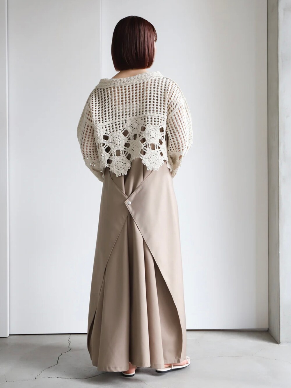 ホワイト系のニット/セーター、ベージュ系のジャンパースカート、ホワイト系のキャミソールを着用したレディースの春コーディネートの2枚目の写真