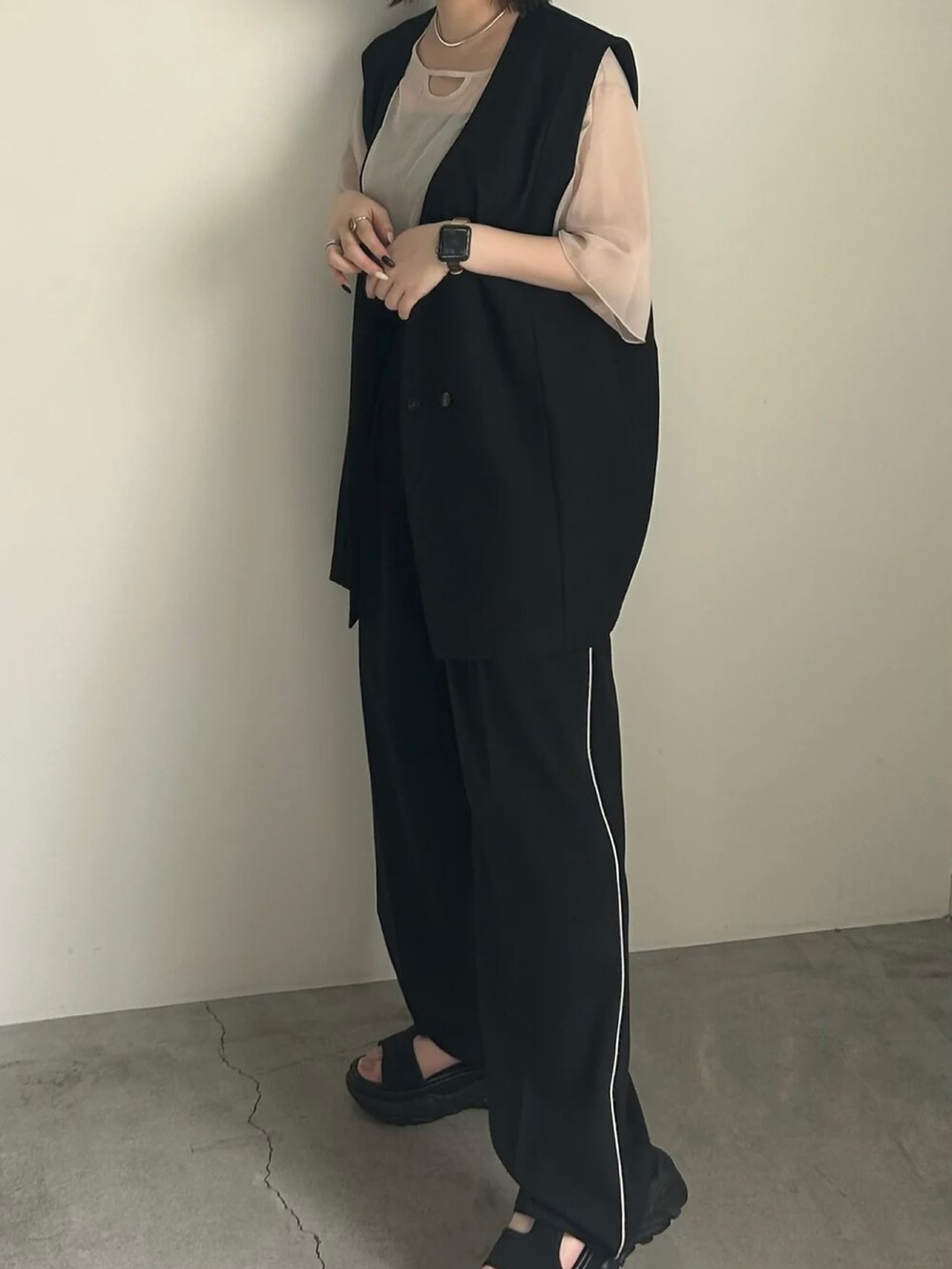 ホワイト系のシャツ/ブラウス、ブラック系のベスト、ブラック系のスラックスを着用したレディースの春コーディネートの3枚目の写真