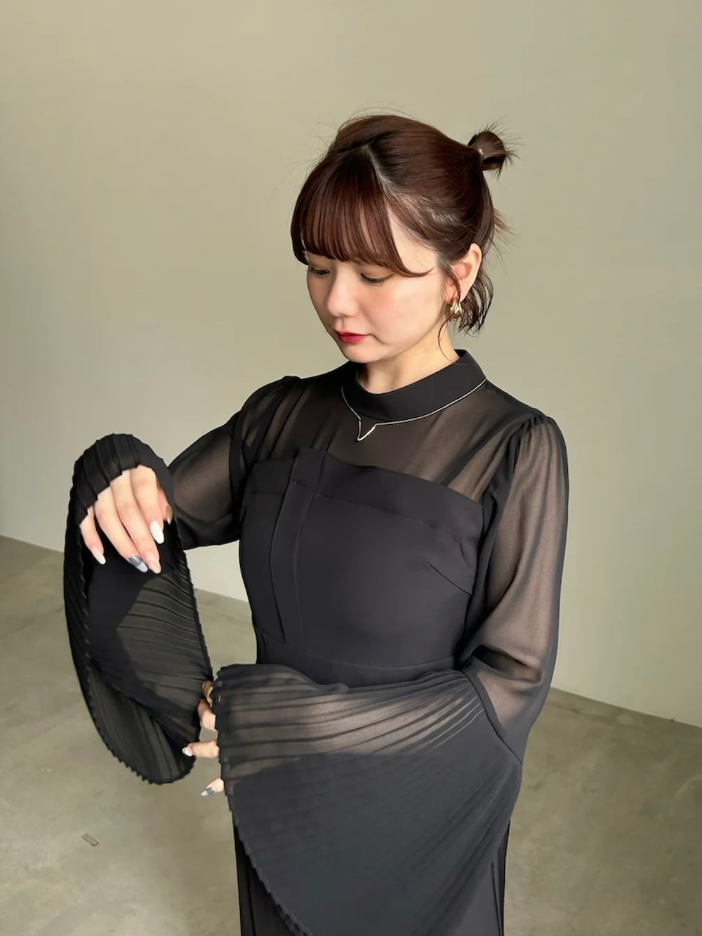 グレー系のワンピース、ブラック系のショルダーバッグ、ブラック系のパンプスを着用したレディースの春コーディネートの3枚目の写真