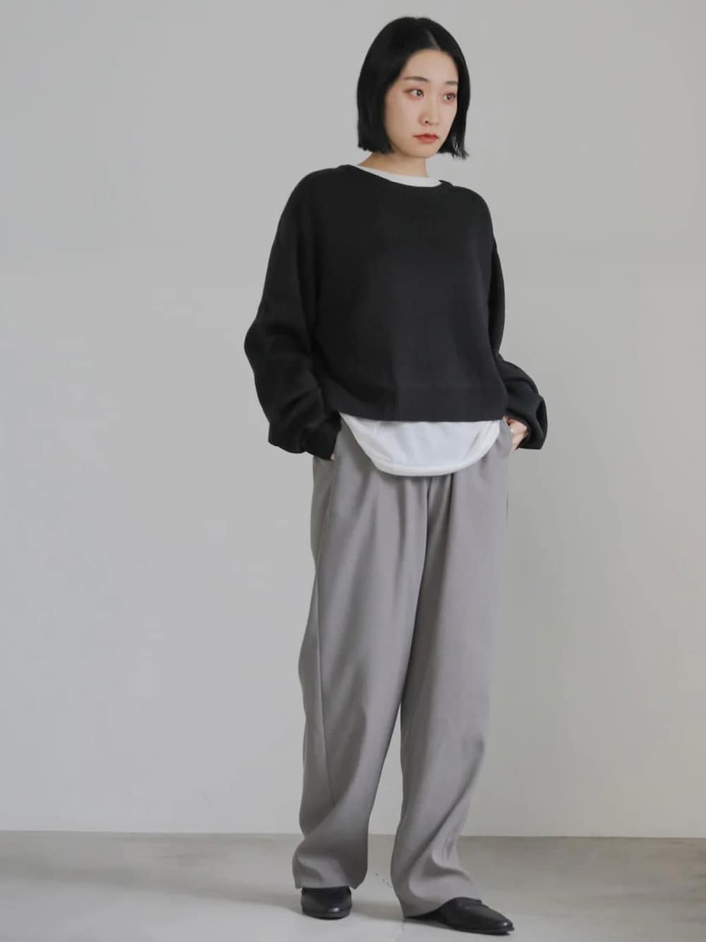ブラック系のニット/セーター、グレー系のその他パンツを着用したレディースの冬コーディネートの3枚目の写真