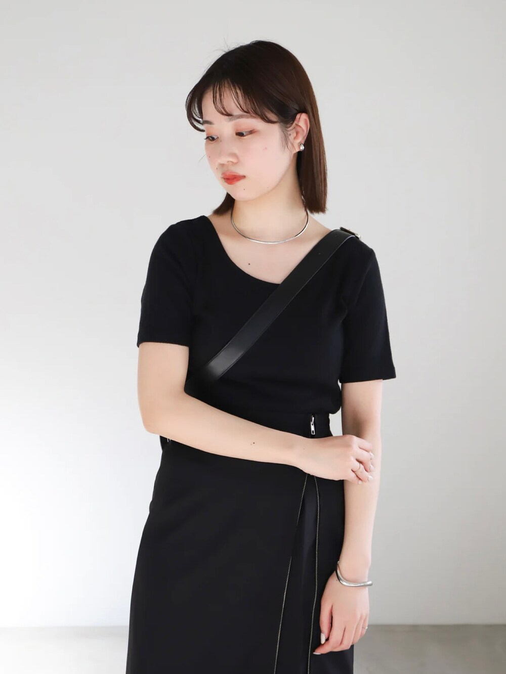 ブラック系のTシャツ/カットソー、ブラック系のスカート、ブラック系のスラックスを着用したレディースの春コーディネートの4枚目の写真