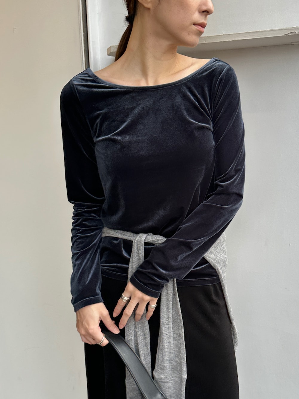 ブルー系のTシャツ/カットソー、グレー系のカーディガン/ボレロ、ブラック系のスカートを着用したレディースの冬コーディネートの5枚目の写真