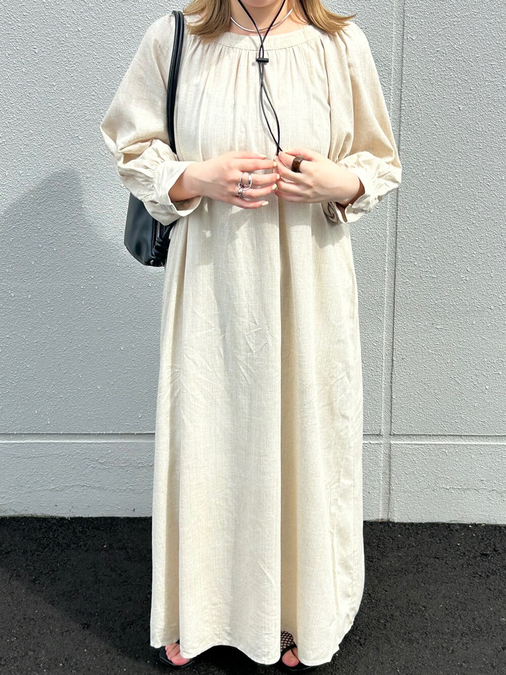 ベージュ系のワンピース、ブラック系のショルダーバッグ、グリーン系のキャップを着用したレディースの夏コーディネートの2枚目の写真