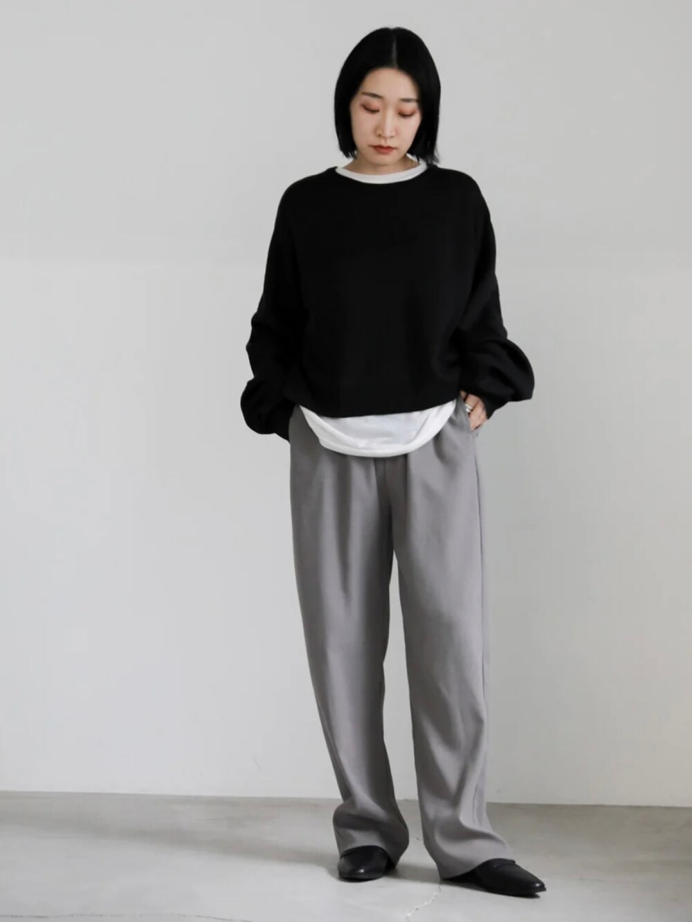 ブラック系のニット/セーター、グレー系のその他パンツを着用したレディースの冬コーディネートの5枚目の写真