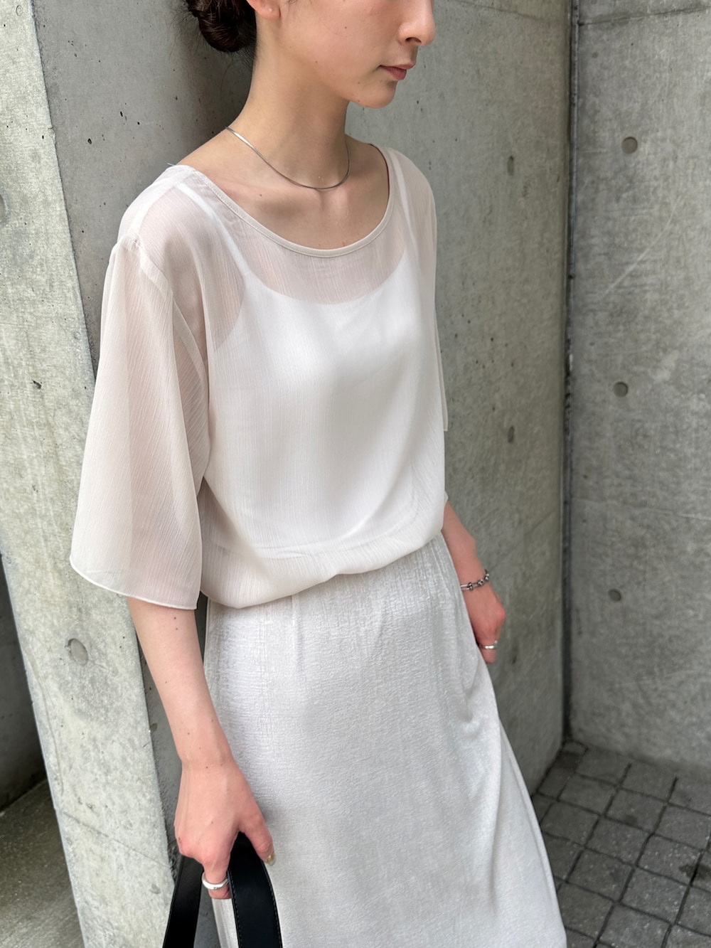 ホワイト系のシャツ/ブラウス、ホワイト系のスカート、ブラック系のショルダーバッグを着用したレディースの夏コーディネートの3枚目の写真