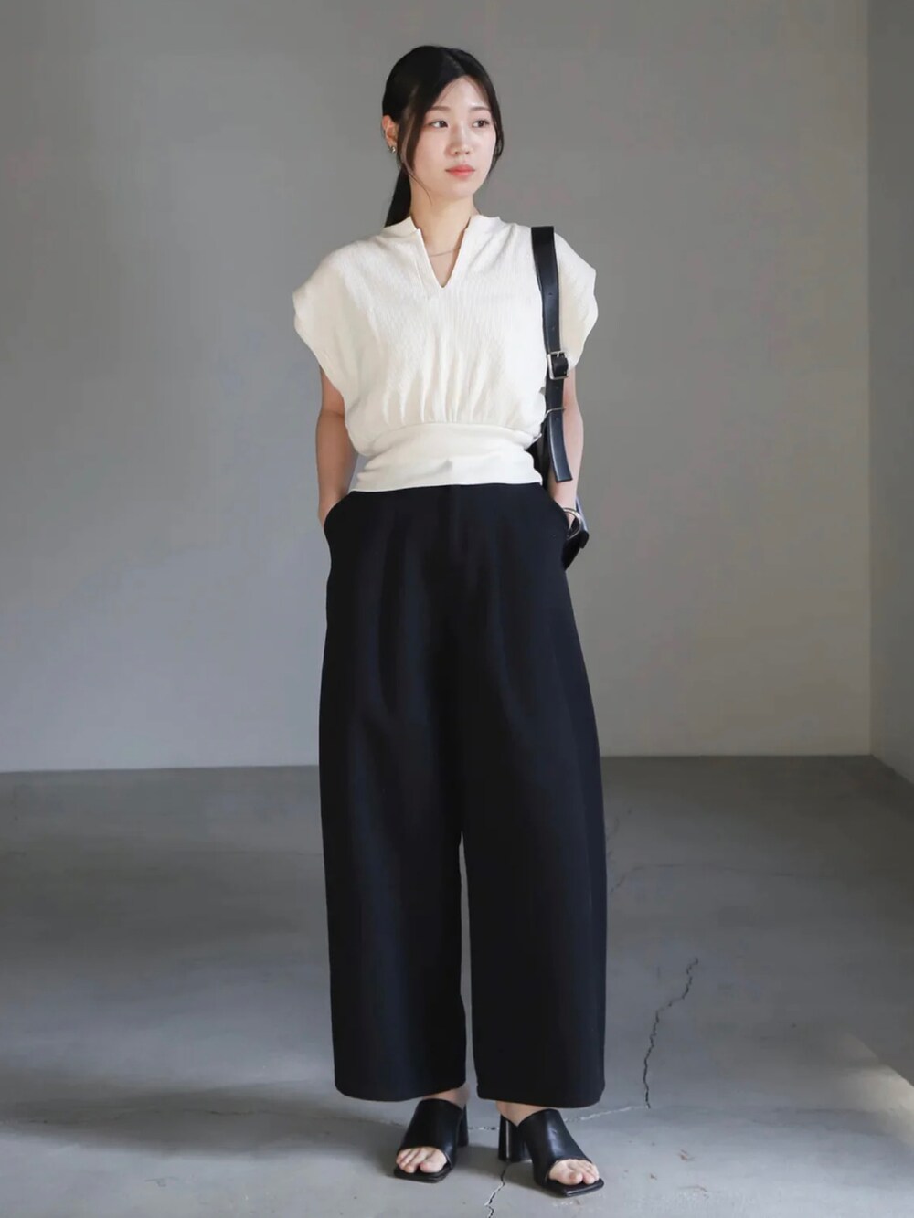 ホワイト系のTシャツ/カットソー、ホワイト系のキャミソール、ブラック系のデニムパンツを着用したレディースの春コーディネートの2枚目の写真