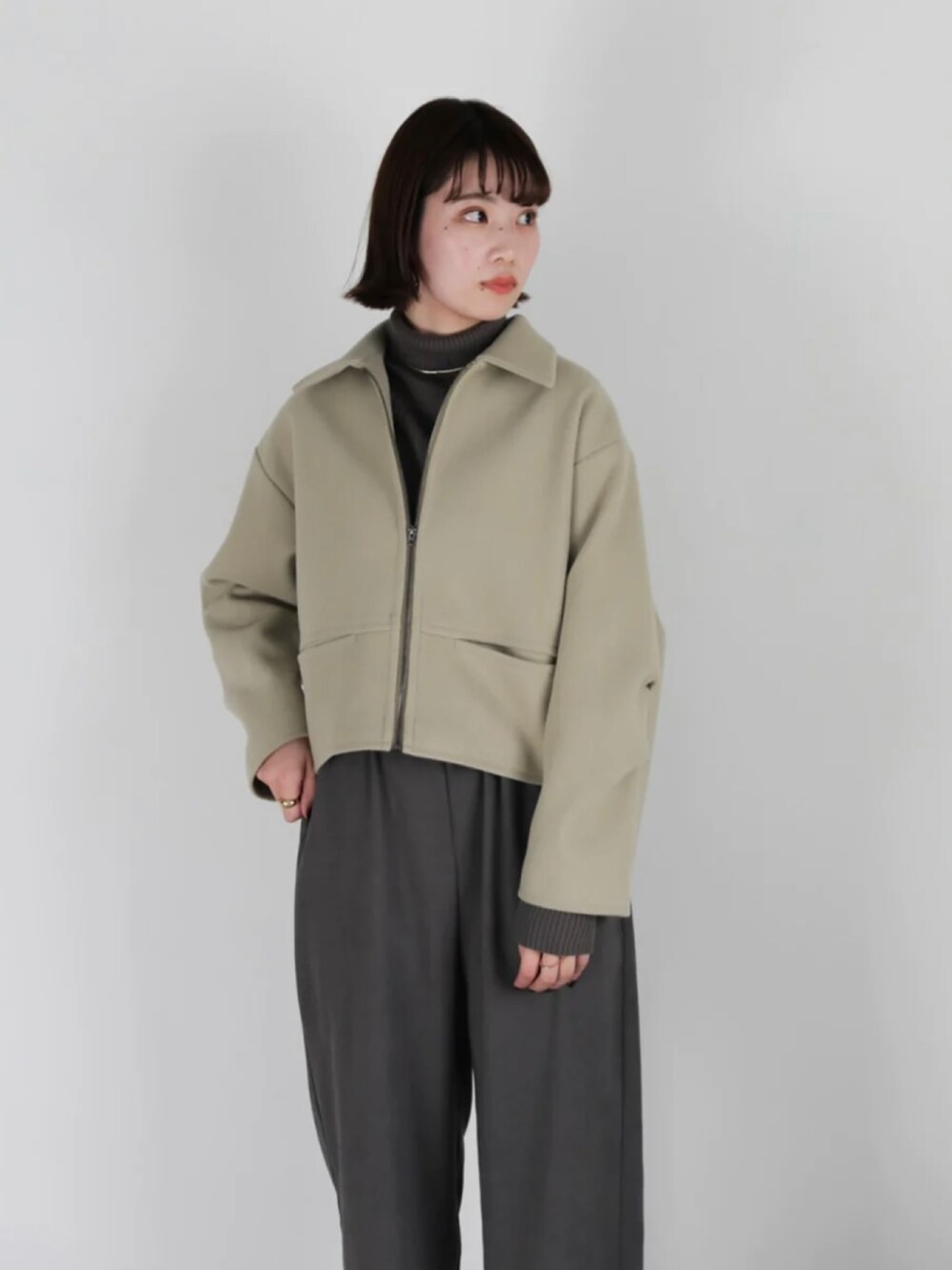 グリーン系のブルゾン、ブラック系のその他パンツ、ブラック系のブーツを着用したレディースの冬コーディネートの4枚目の写真