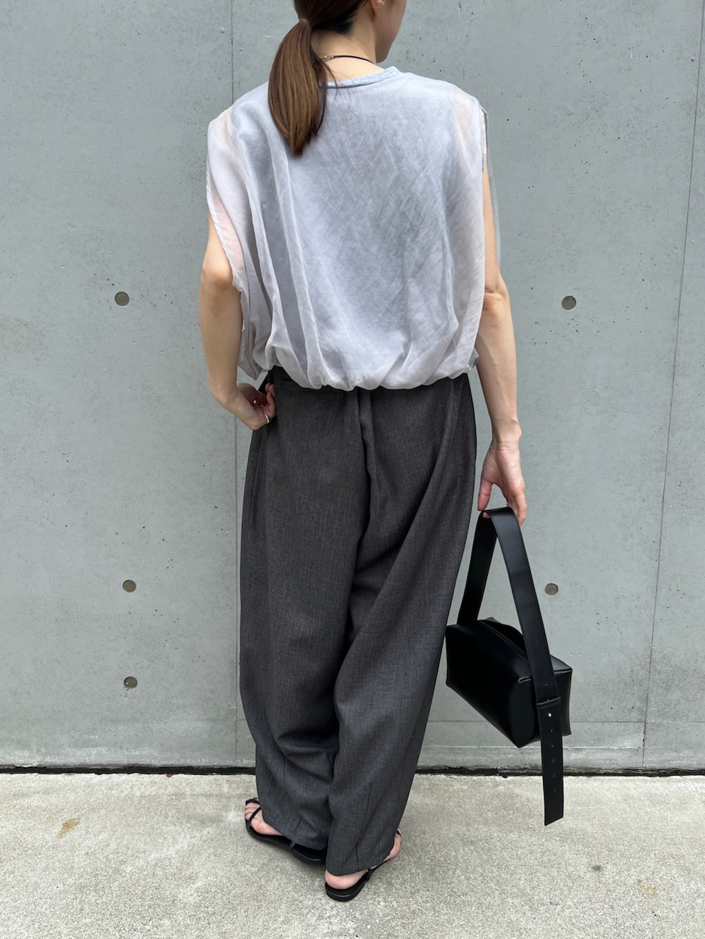 グレー系のシャツ/ブラウス、ブラック系のショルダーバッグ、グレー系のスラックスを着用したレディースの夏コーディネートの2枚目の写真