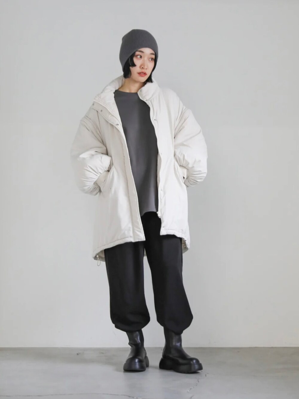 グレー系のスウェット、ホワイト系のダウンジャケット/コート、ブラック系のその他パンツを着用したレディースの冬コーディネートの2枚目の写真