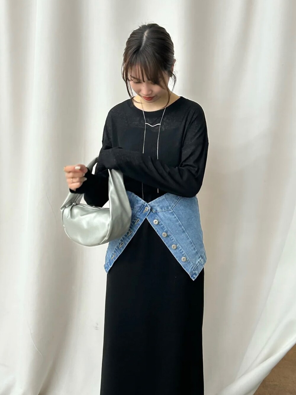 ブラック系のTシャツ/カットソー、ブラック系のスカート、ブルー系のチューブトップを着用したレディースの冬コーディネートの4枚目の写真