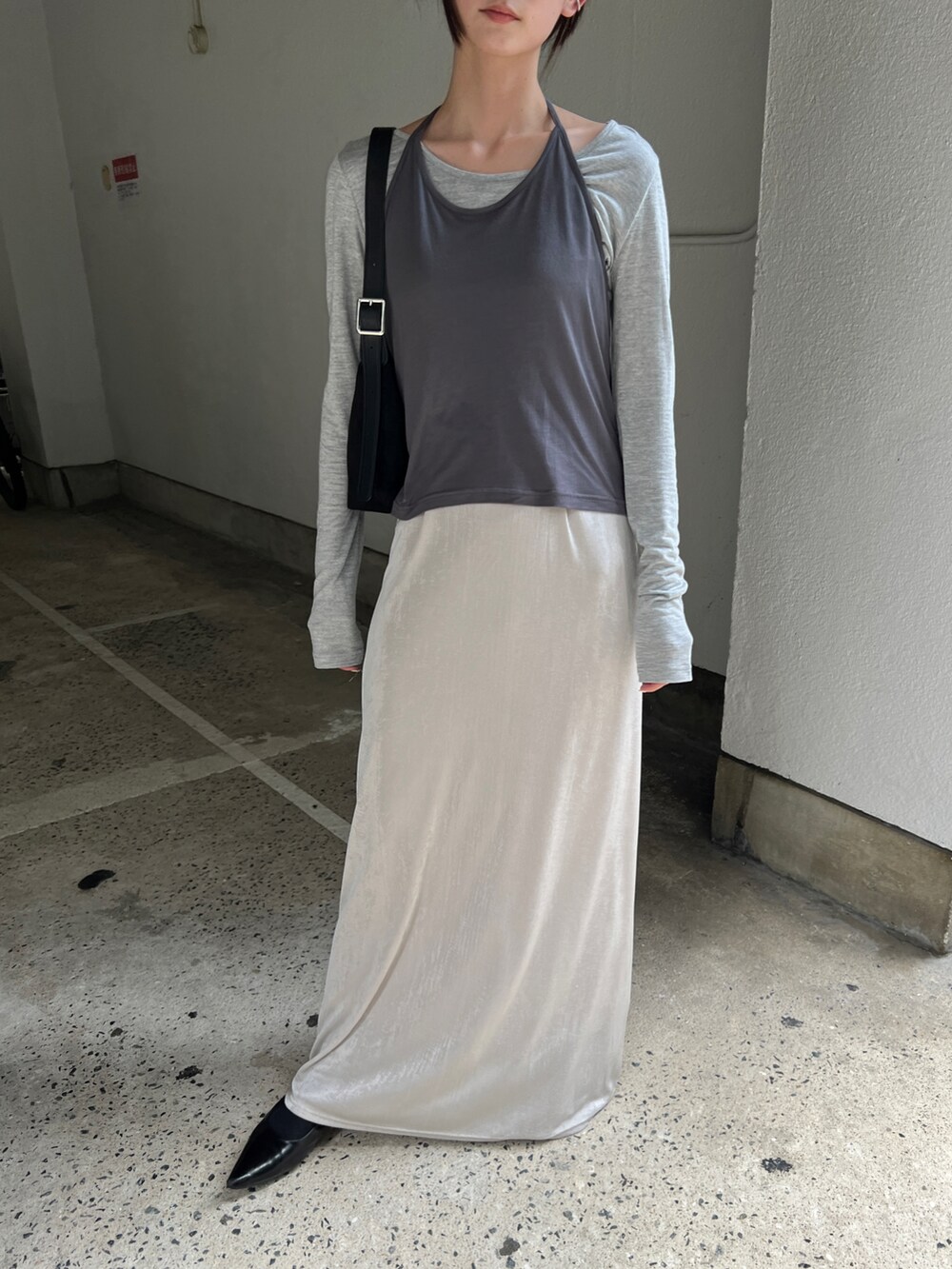 グレー系のTシャツ/カットソー、ホワイト系のスカート、ブラック系のショルダーバッグを着用したレディースの秋コーディネートの2枚目の写真