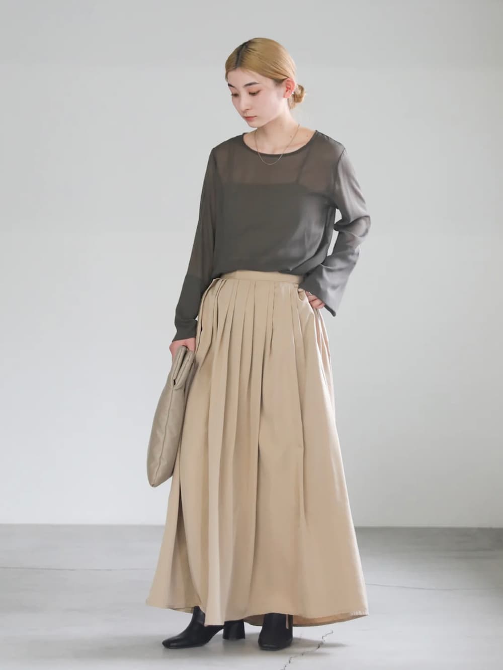 グレー系のシャツ/ブラウス、ベージュ系のハンドバッグ、ベージュ系のスカートを着用したレディースの春コーディネートの2枚目の写真