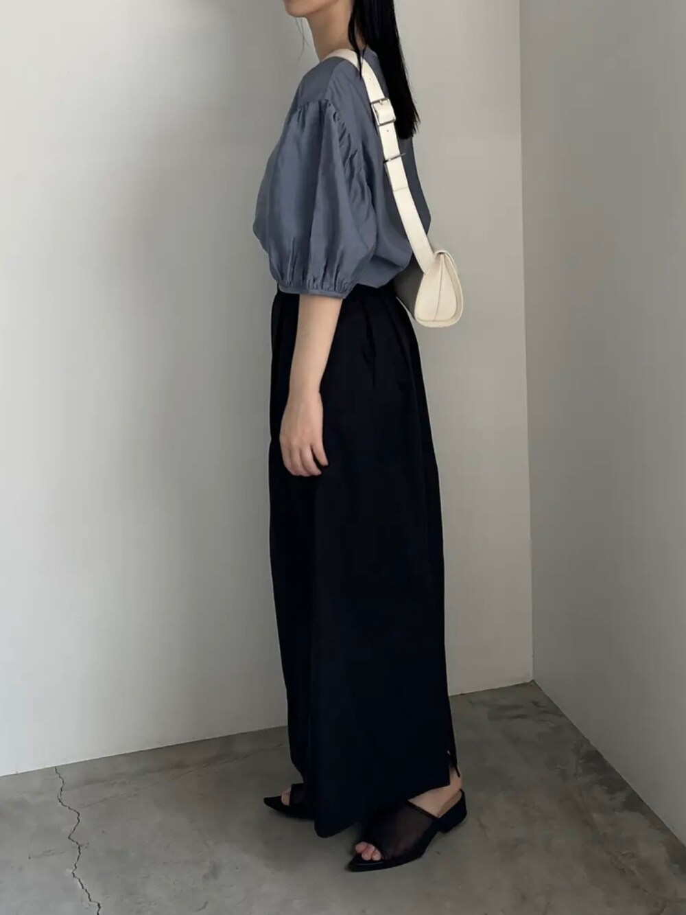 ブルー系のシャツ/ブラウス、ブラック系のスカート、ホワイト系のショルダーバッグを着用したレディースの夏コーディネートの2枚目の写真