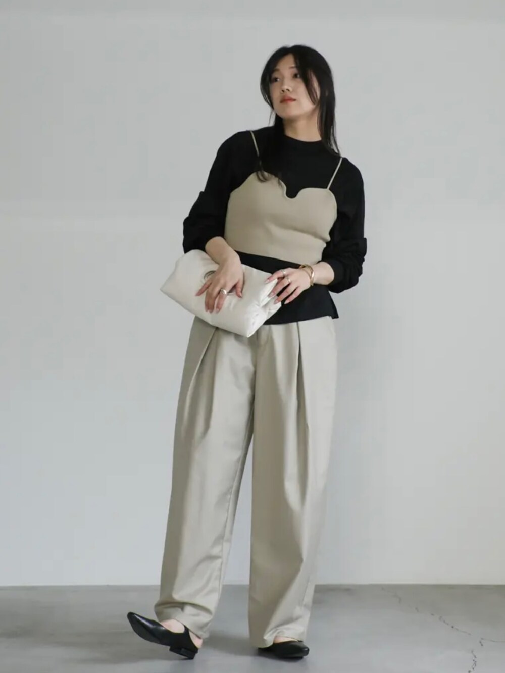 ベージュ系のベスト、ブラック系のTシャツ/カットソー、ベージュ系のスラックスを着用したレディースの夏コーディネートの2枚目の写真