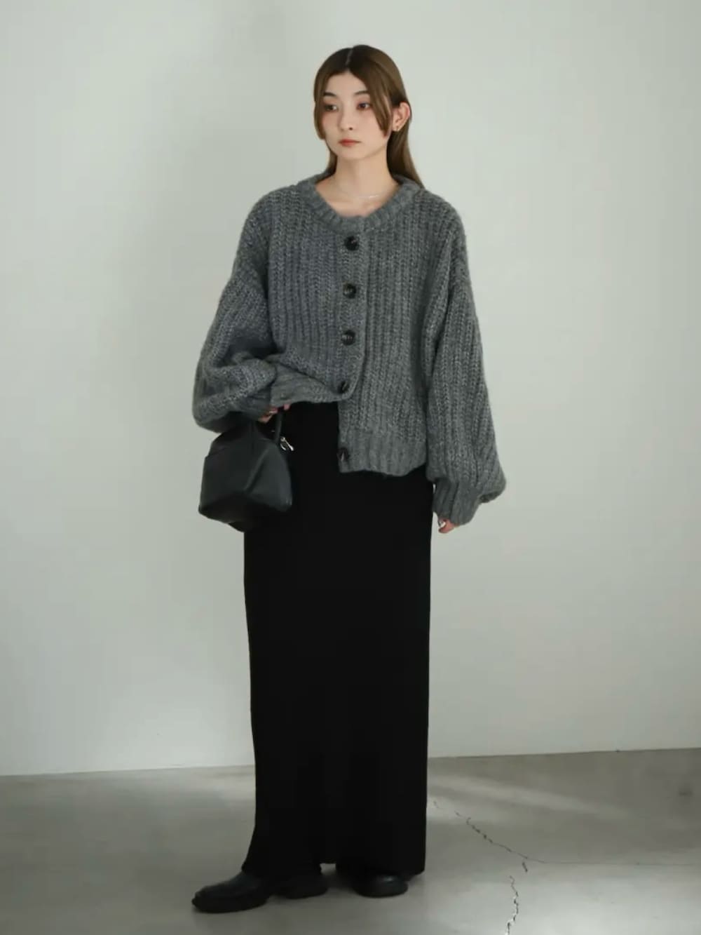 グレー系のカーディガン/ボレロ、ブラック系のスカート、ブラック系のスリッポンを着用したレディースの夏コーディネートの2枚目の写真