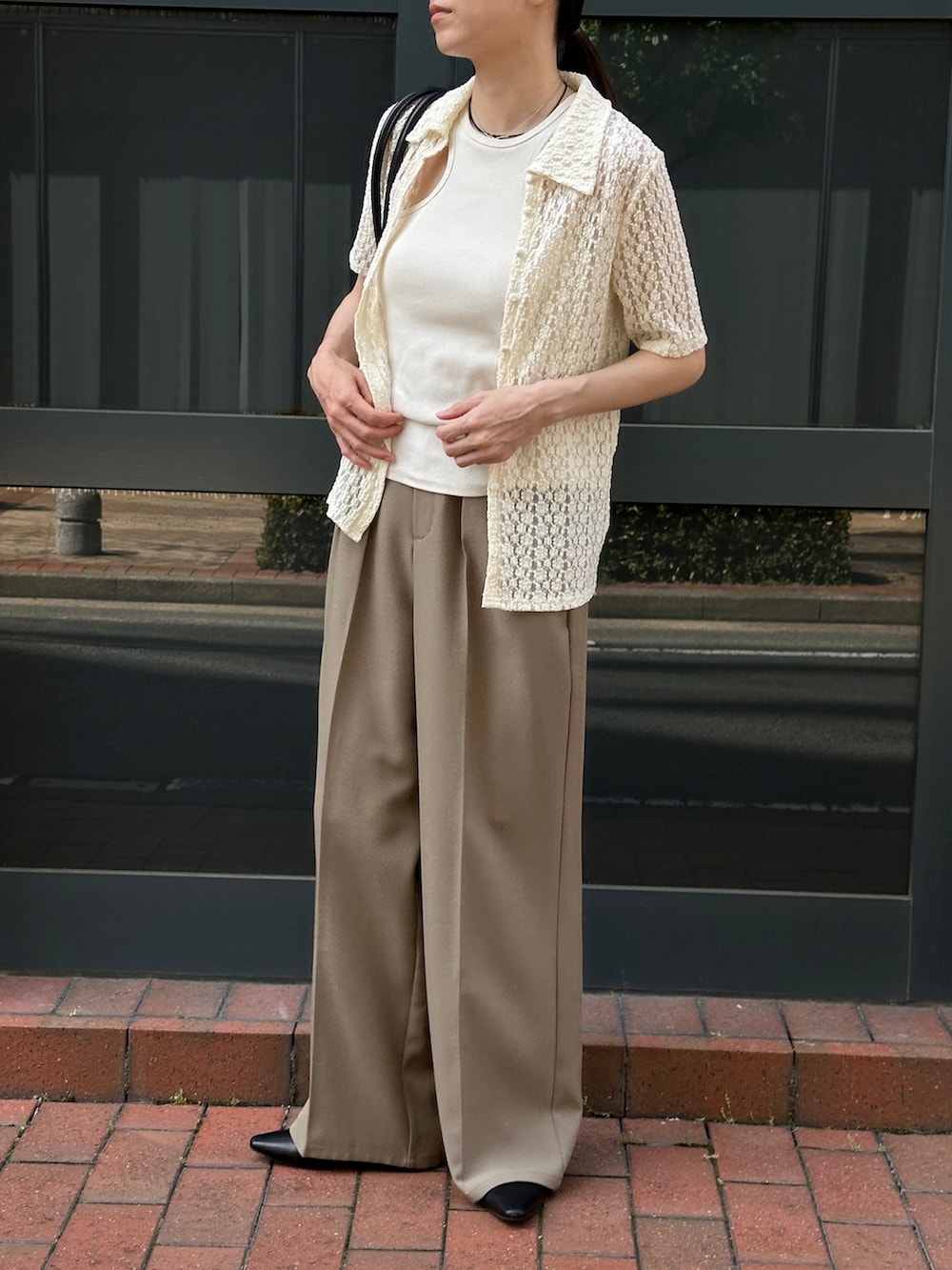 ホワイト系のタンクトップ、ホワイト系のシャツ/ブラウス、ベージュ系のスラックスを着用したレディースの春コーディネートの2枚目の写真