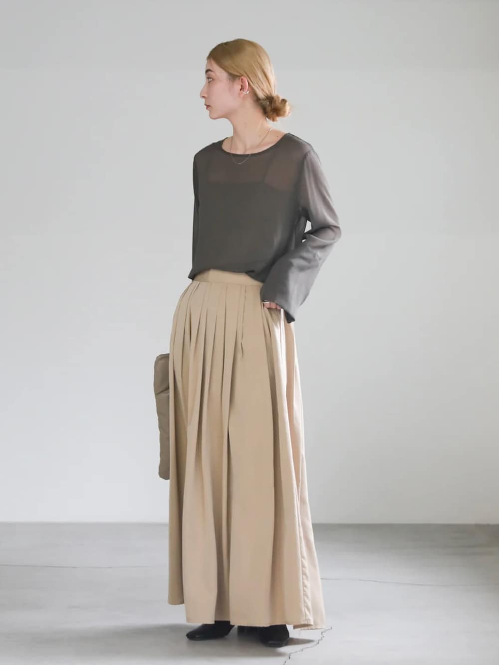 グレー系のシャツ/ブラウス、ベージュ系のハンドバッグ、ベージュ系のスカートを着用したレディースの春コーディネートの3枚目の写真