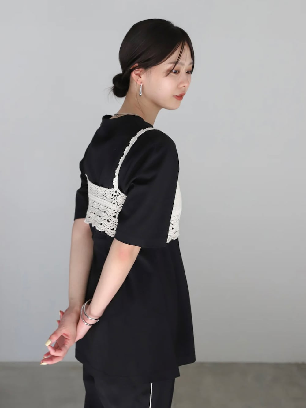 ブラック系のスラックス、ブラック系のサンダル、ブラック系のハンドバッグを着用したレディースの春コーディネートの5枚目の写真