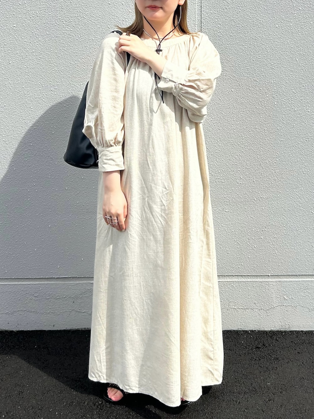 ベージュ系のワンピース、ブラック系のショルダーバッグ、グリーン系のキャップを着用したレディースの夏コーディネートの4枚目の写真