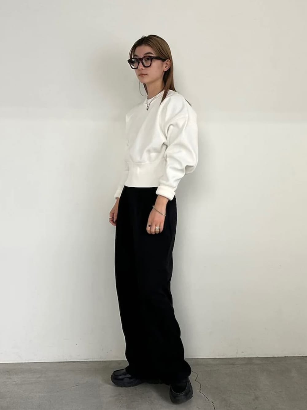 ホワイト系のニット/セーター、ブラック系のスラックスを着用したレディースの冬コーディネートの4枚目の写真