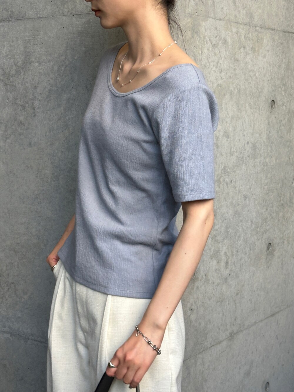 ブルー系のTシャツ/カットソー、ホワイト系のスラックス、ブラック系のトートバッグを着用したレディースの春コーディネートの3枚目の写真