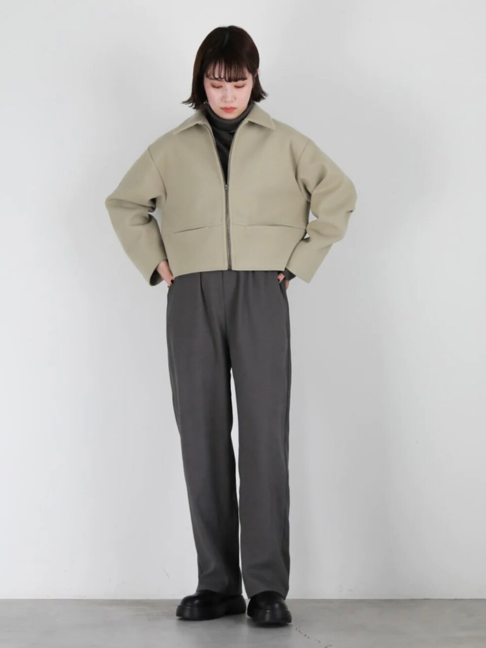 グリーン系のブルゾン、ブラック系のその他パンツ、ブラック系のブーツを着用したレディースの冬コーディネートの2枚目の写真