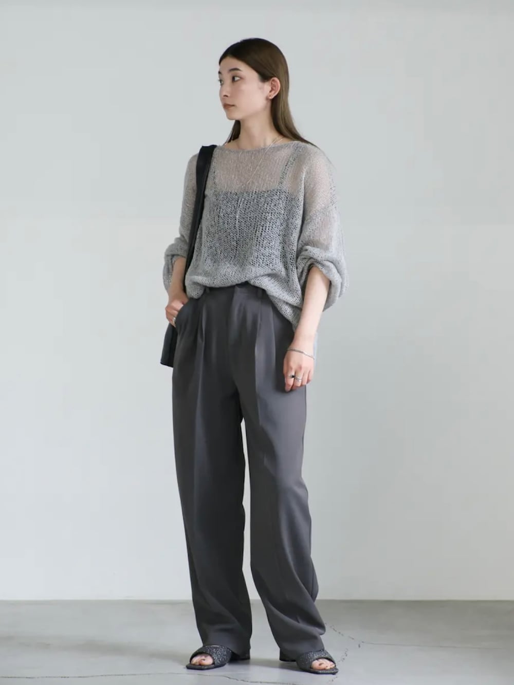 グレー系のニット/セーター、グレー系のスラックス、ブラック系のサンダルを着用したレディースの夏コーディネートの3枚目の写真