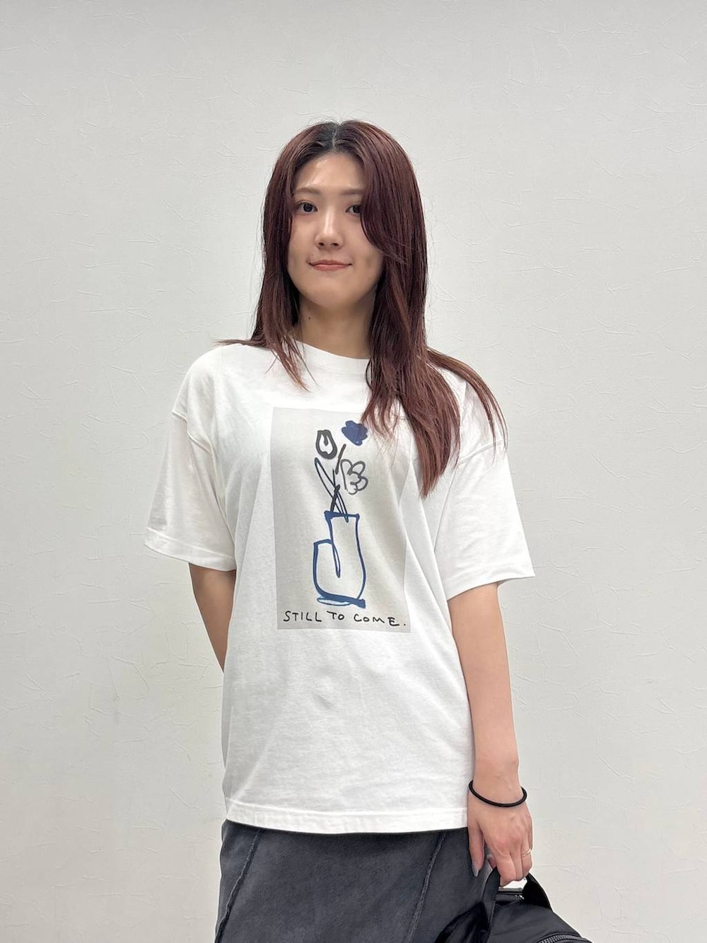 ブラック系のスカート、ホワイト系のTシャツ/カットソー、ブラック系のバックパック/リュックを着用したレディースの夏コーディネートの4枚目の写真