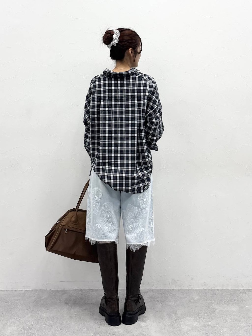 ブラウン系のボストンバッグ、ホワイト系のTシャツ/カットソー、ブラウン系のブーツを着用したレディースの夏コーディネートの7枚目の写真
