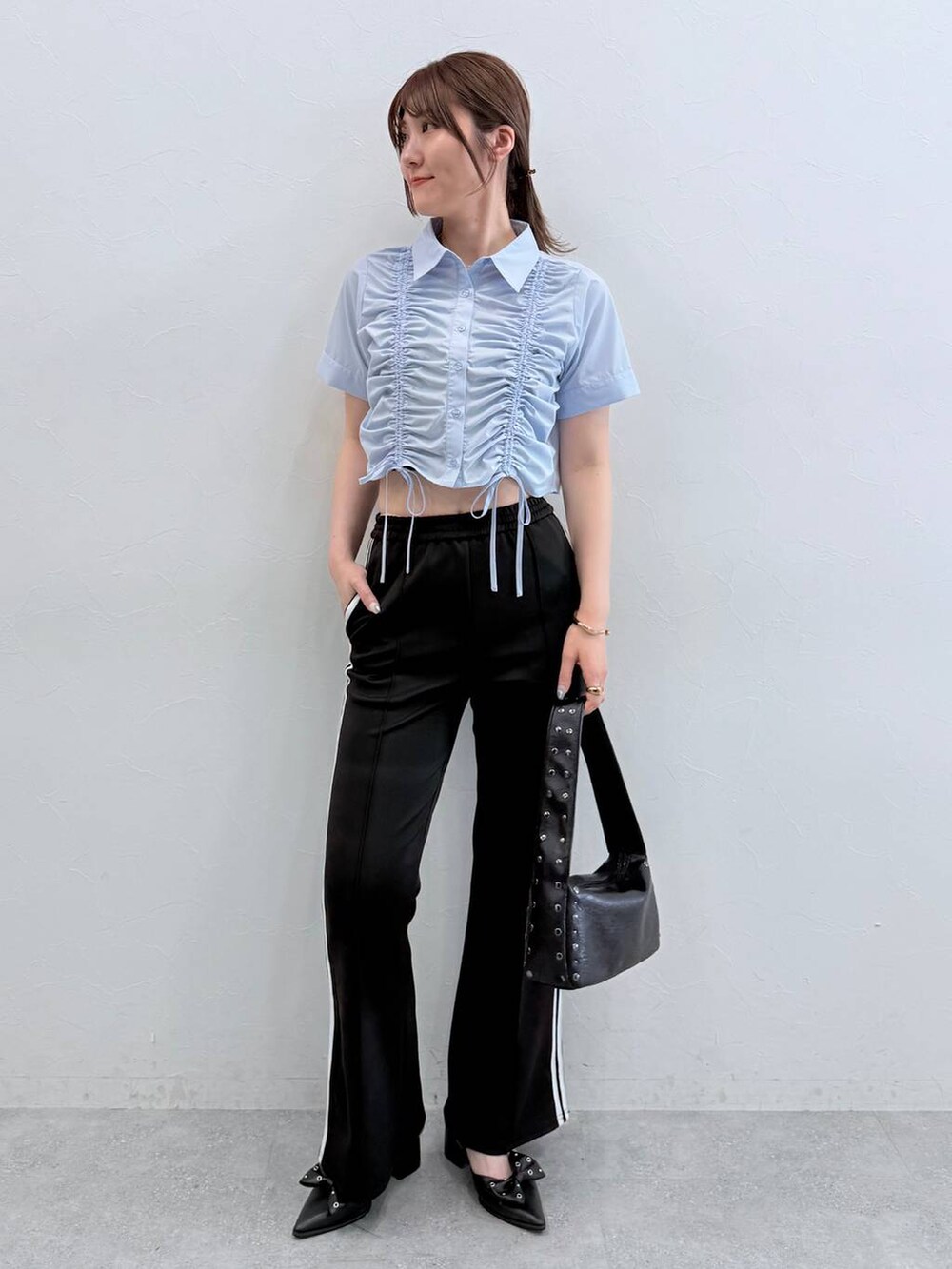 ブラック系のパンプス、ブラック系のその他パンツ、ブラック系のハンドバッグを着用したレディースの春コーディネートの2枚目の写真