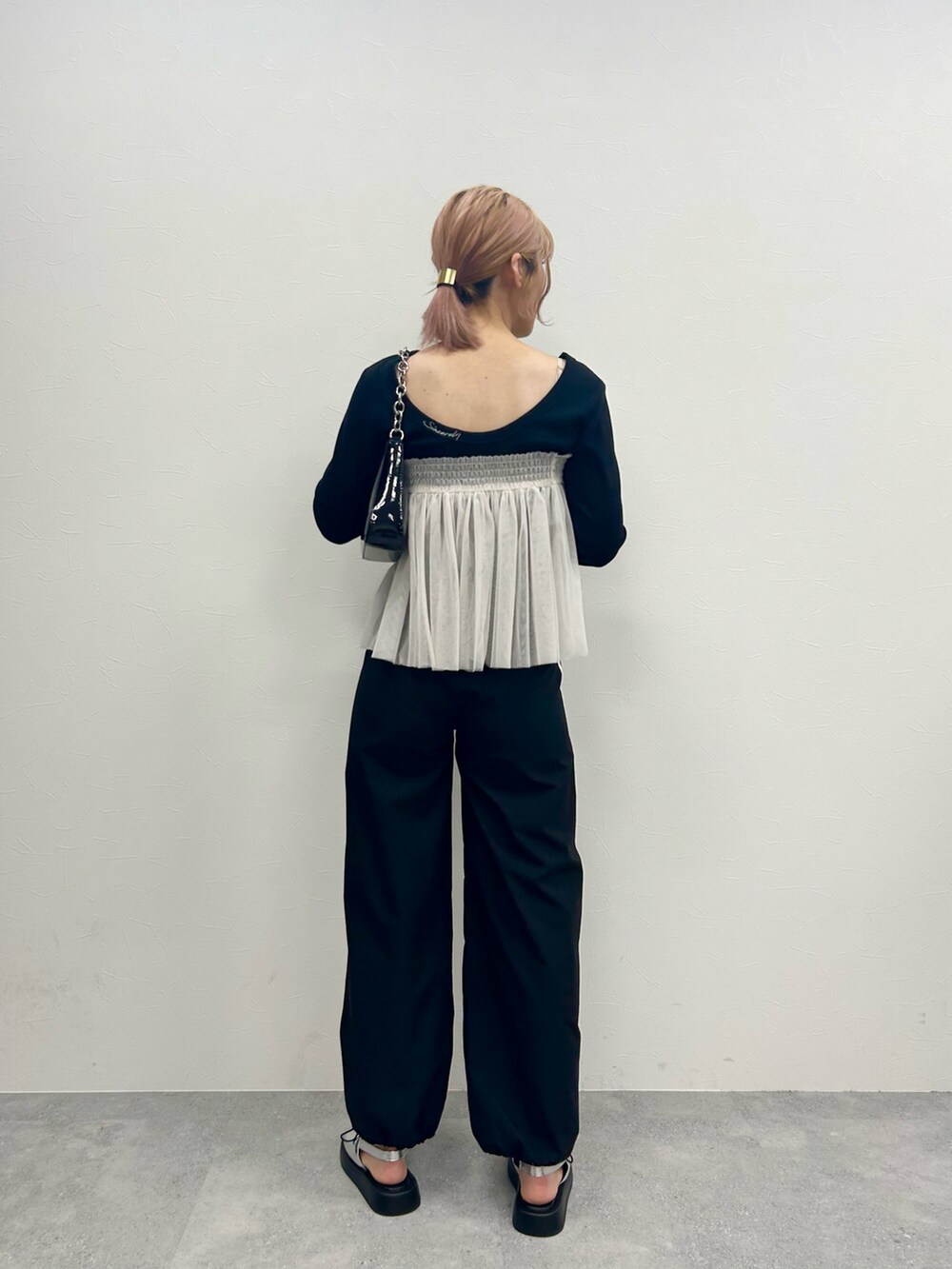 ブラック系のその他パンツ、ホワイト系のチューブトップ、ブラック系のTシャツ/カットソーを着用したレディースの春コーディネートの3枚目の写真