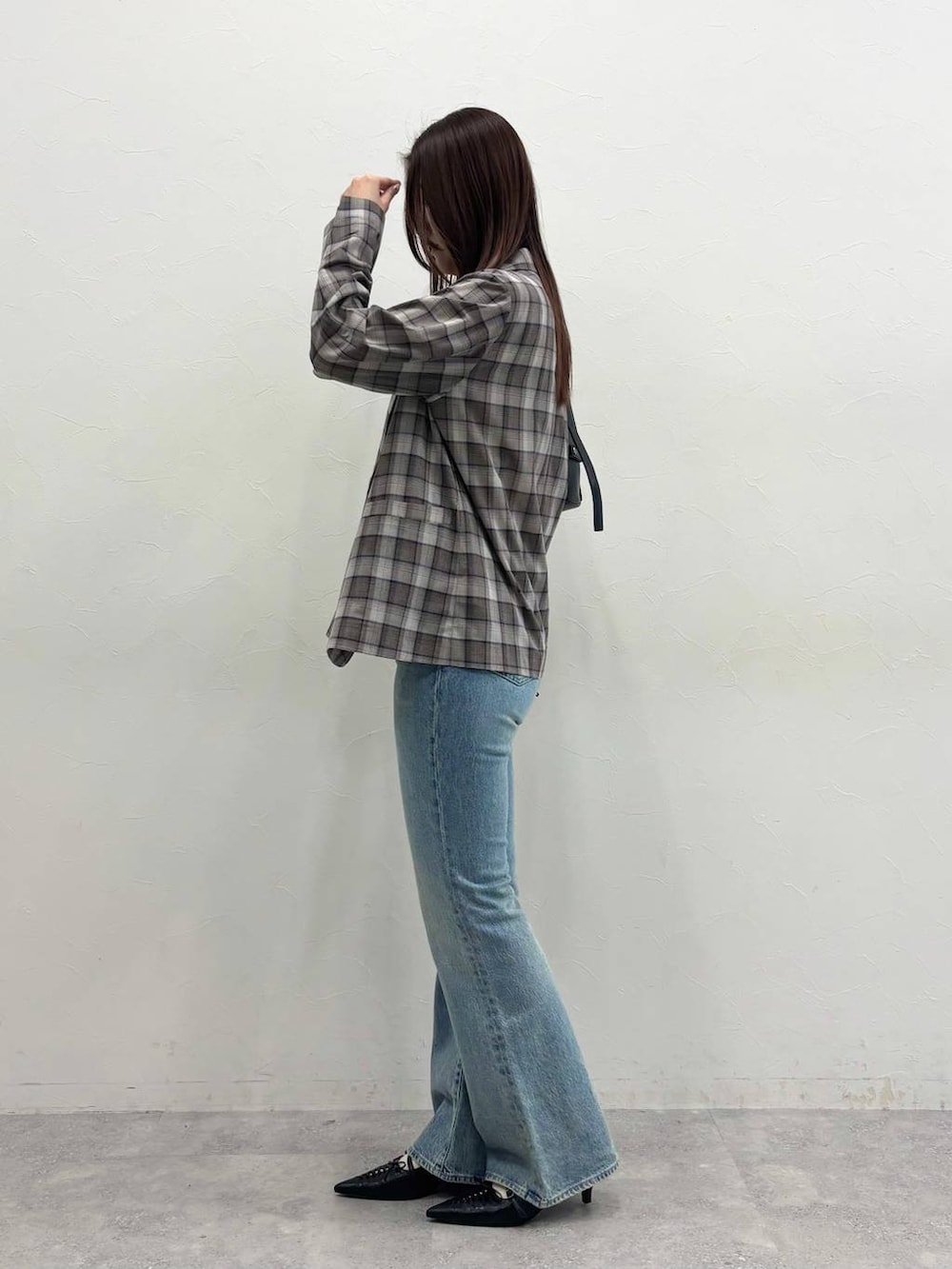 ブルー系のデニムパンツ、グレー系のテーラードジャケット、ブラック系のショルダーバッグを着用したレディースの春コーディネートの2枚目の写真