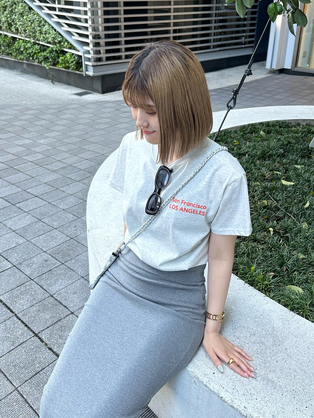 グレー系のスカート、グレー系のTシャツ/カットソー、シルバー系のサンダルを着用したレディースの春コーディネートの5枚目の写真