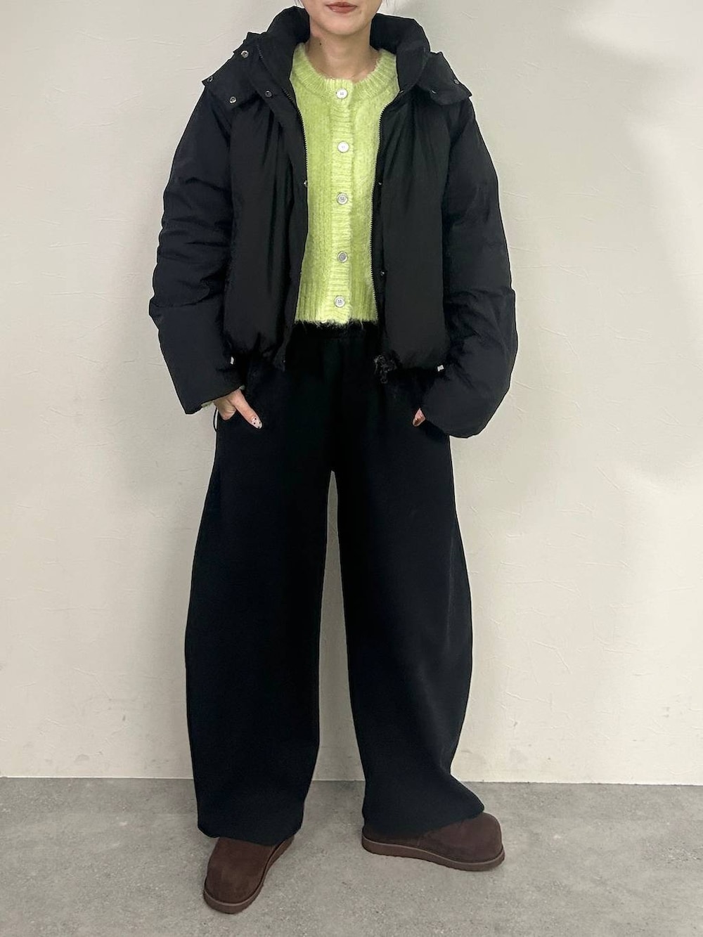 ブラウン系のその他シューズ、ブラック系のスウェットパンツ、グリーン系のカーディガン/ボレロを着用したレディースの冬コーディネートの3枚目の写真