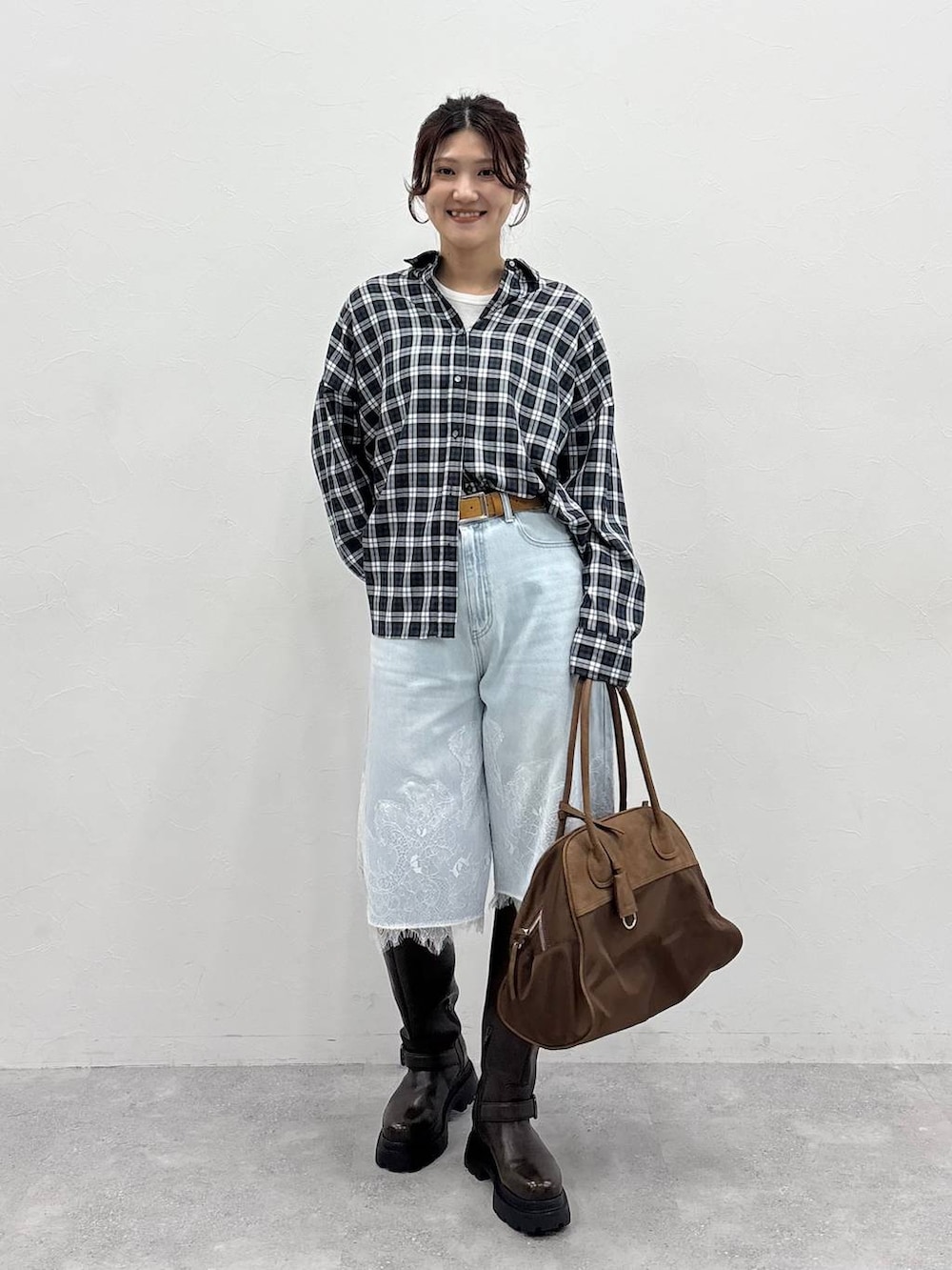 ブラウン系のボストンバッグ、ホワイト系のTシャツ/カットソー、ブラウン系のブーツを着用したレディースの夏コーディネートの4枚目の写真