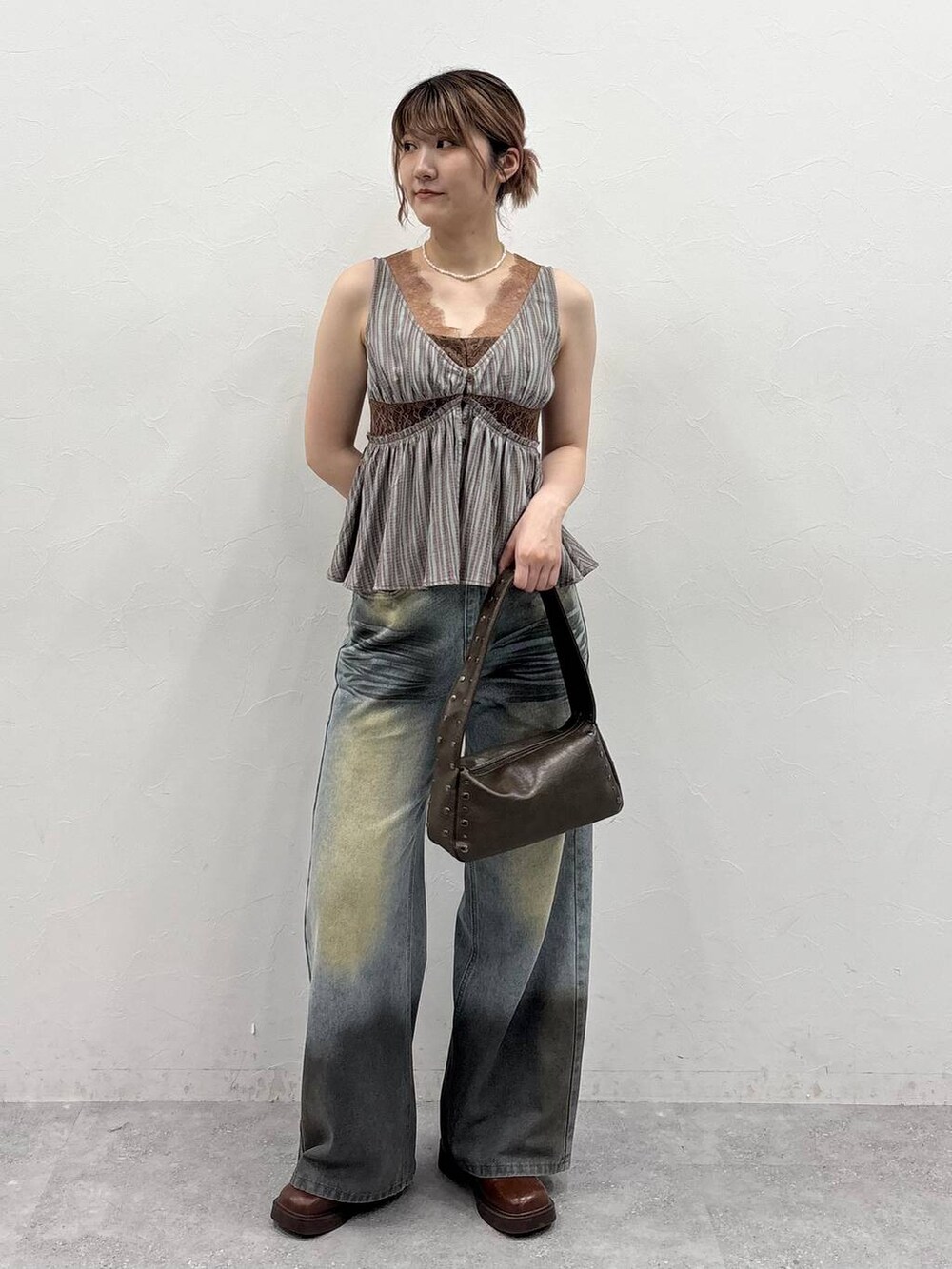 ブラウン系のブーツ、ブルー系のデニムパンツ、ベージュ系のシャツ/ブラウスを着用したレディースの春コーディネートの2枚目の写真