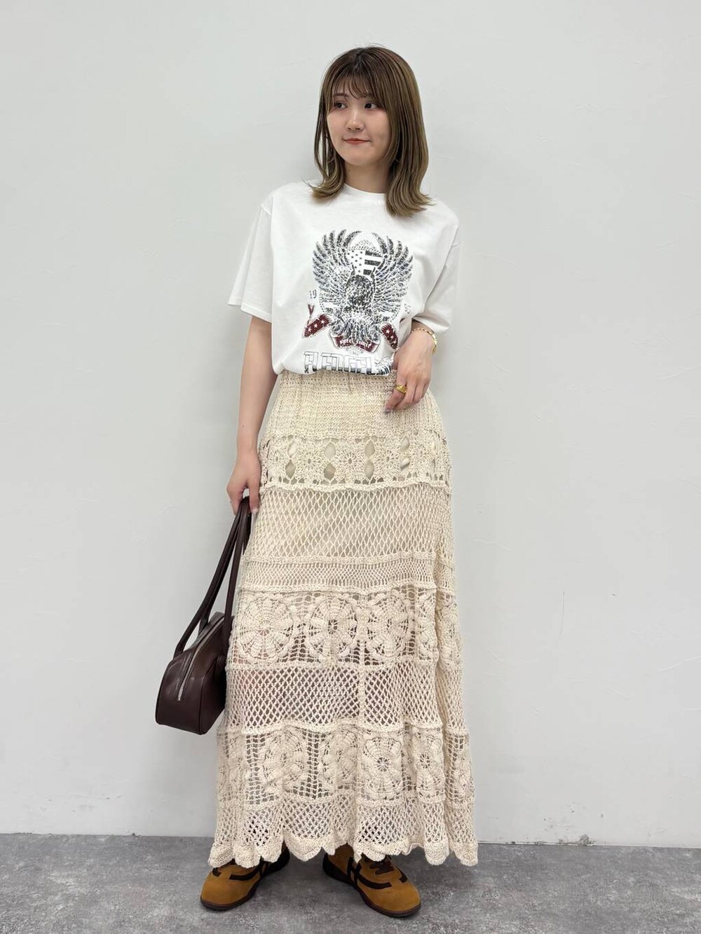 ホワイト系のTシャツ/カットソー、ブラウン系のボストンバッグ、ブラウン系のスニーカーを着用したレディースの春コーディネートの2枚目の写真