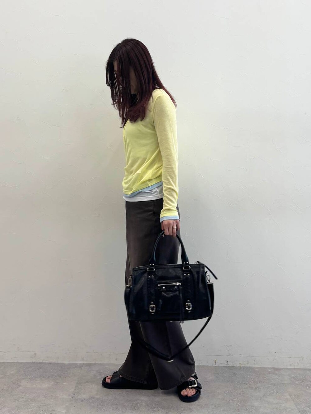 ブラック系のボストンバッグ、ブラック系のサンダル、ブラウン系のデニムパンツを着用したレディースの春コーディネートの3枚目の写真