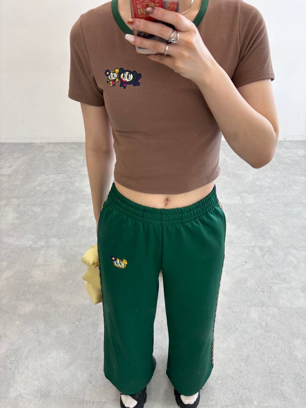 ブラック系のサンダル、グリーン系のその他パンツ、ベージュ系のTシャツ/カットソーを着用したレディースの春コーディネートの3枚目の写真