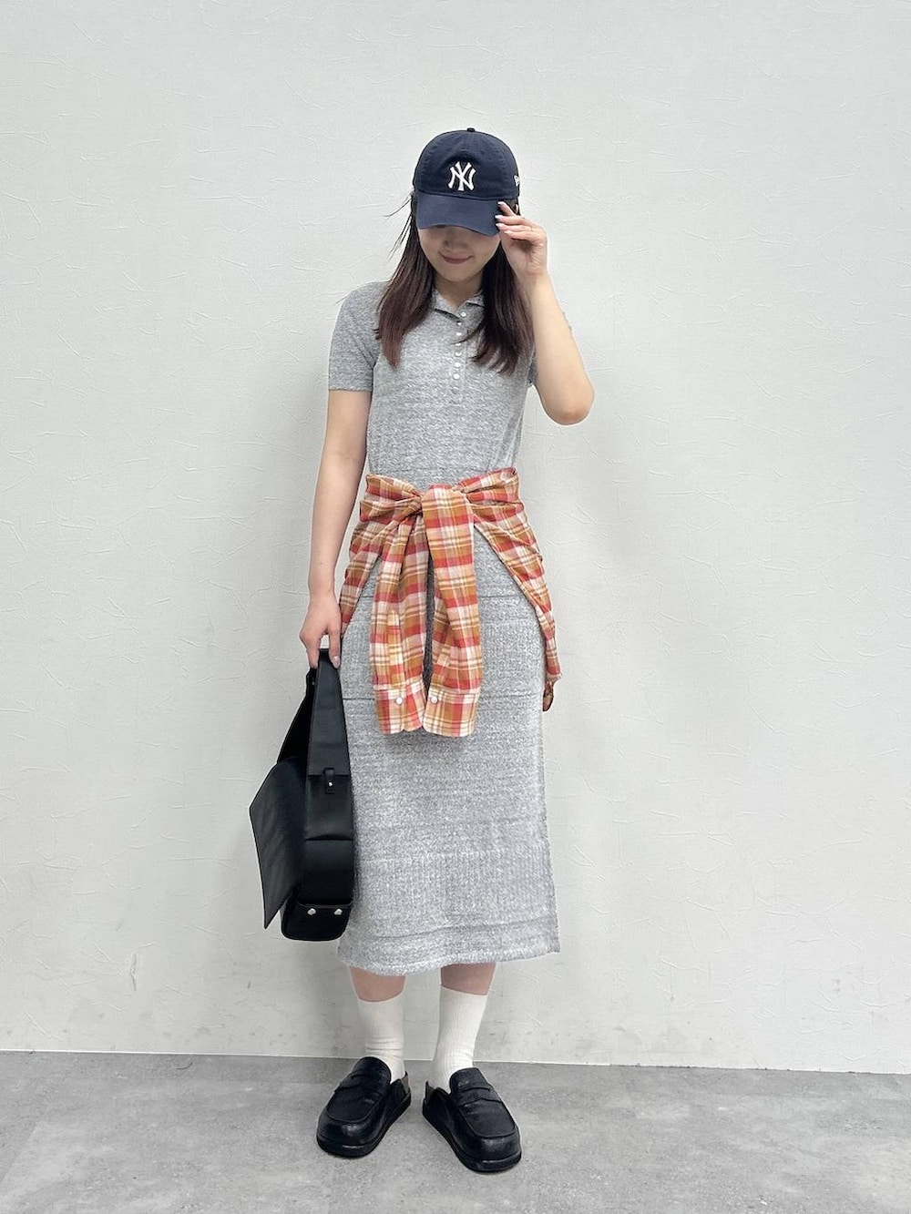 ブラック系のローファー、グレー系のワンピース、ブラック系のショルダーバッグを着用したレディースの春コーディネートの2枚目の写真