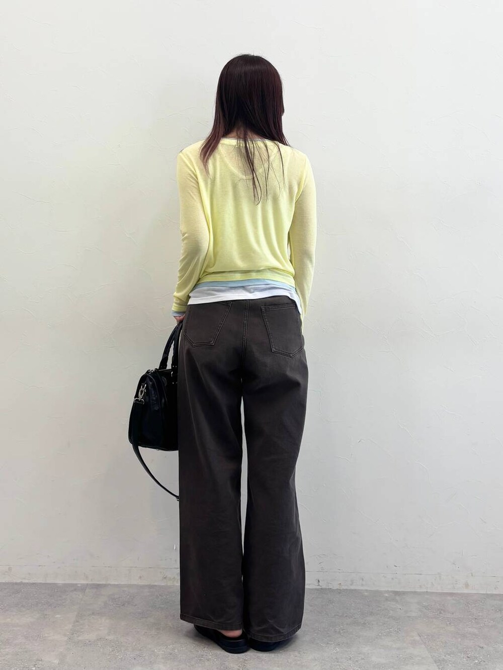 ブラック系のボストンバッグ、ブラック系のサンダル、ブラウン系のデニムパンツを着用したレディースの春コーディネートの4枚目の写真