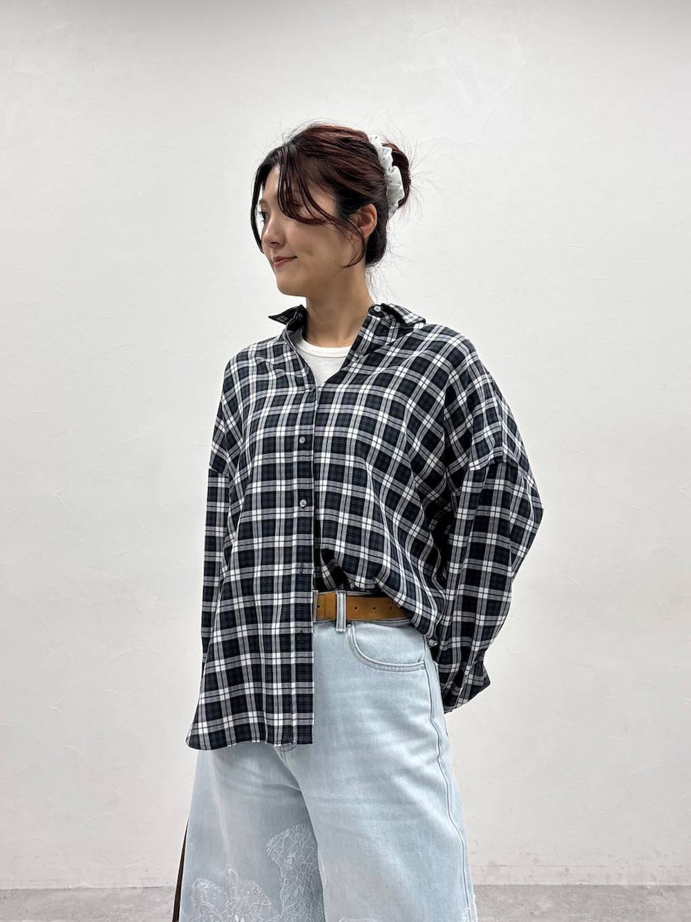 ブラウン系のボストンバッグ、ホワイト系のTシャツ/カットソー、ブラウン系のブーツを着用したレディースの夏コーディネートの5枚目の写真