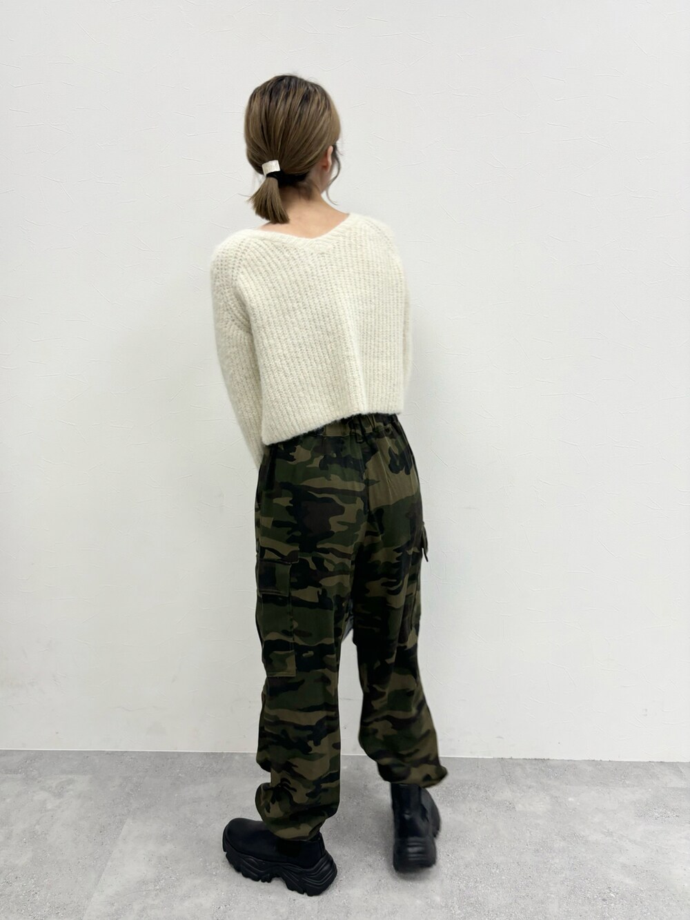 グリーン系のカーゴパンツ、ベージュ系のカーディガン/ボレロ、ブラック系のブーツを着用したレディースの秋コーディネートの5枚目の写真