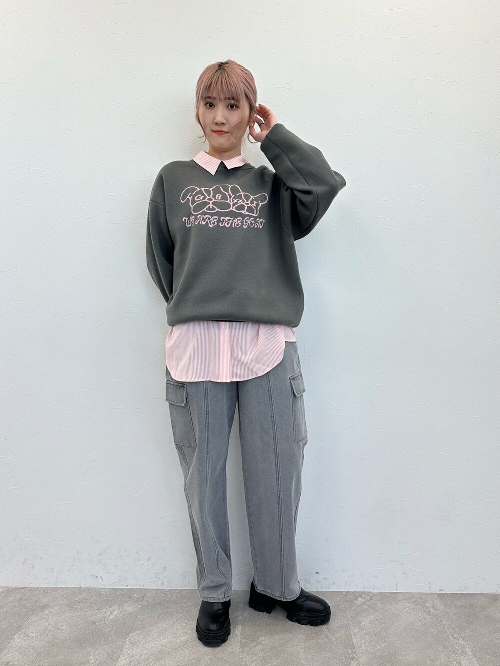 グレー系のニット/セーター、ピンク系のシャツ/ブラウス、ブラック系のデニムパンツを着用したレディースの春コーディネートの2枚目の写真