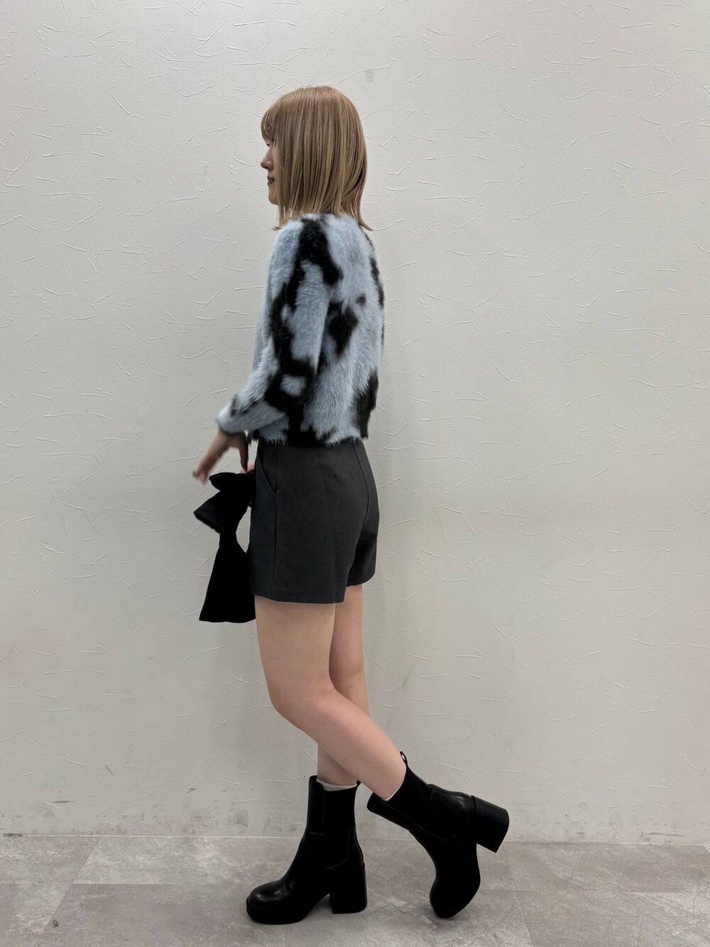 グレー系のその他パンツ、ブラック系のハンドバッグ、ブラック系のブーツを着用したレディースの冬コーディネートの3枚目の写真