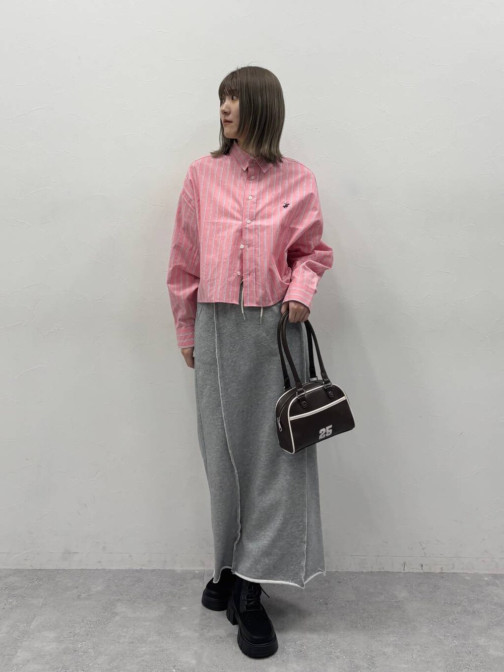 ブラック系のブーツ、レッド系のシャツ/ブラウス、グレー系のスカートを着用したレディースの冬コーディネートの2枚目の写真