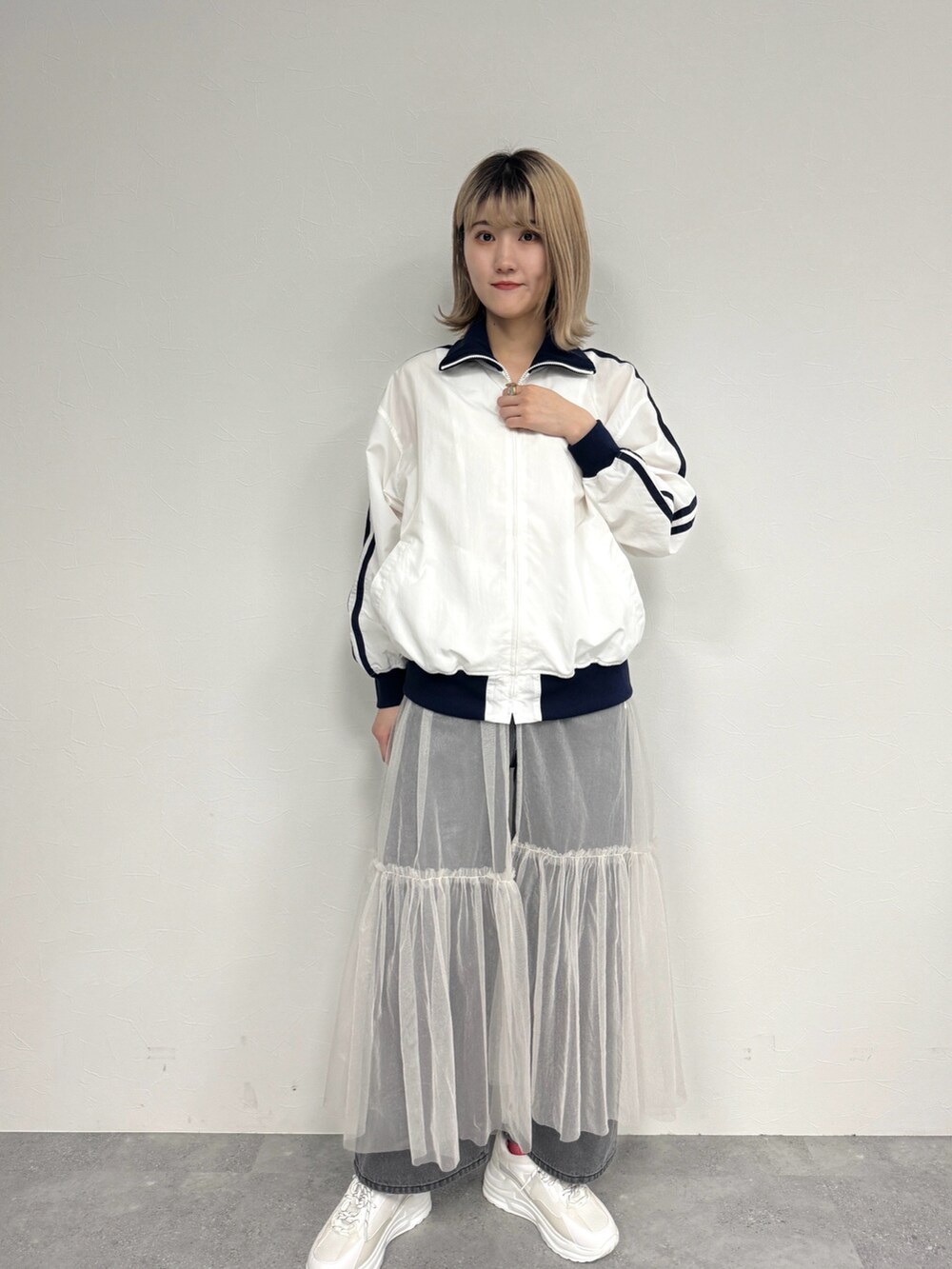 ホワイト系のジャケット/アウター、ホワイト系のワンピース、ホワイト系のスニーカーを着用したレディースの春コーディネートの2枚目の写真