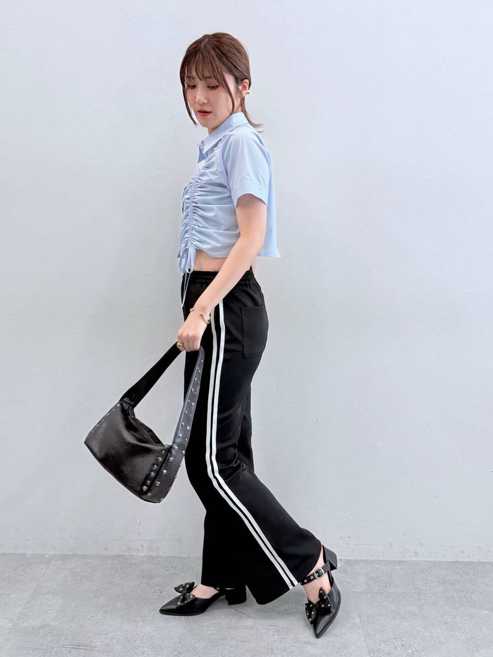 ブラック系のパンプス、ブラック系のその他パンツ、ブラック系のハンドバッグを着用したレディースの春コーディネートの3枚目の写真