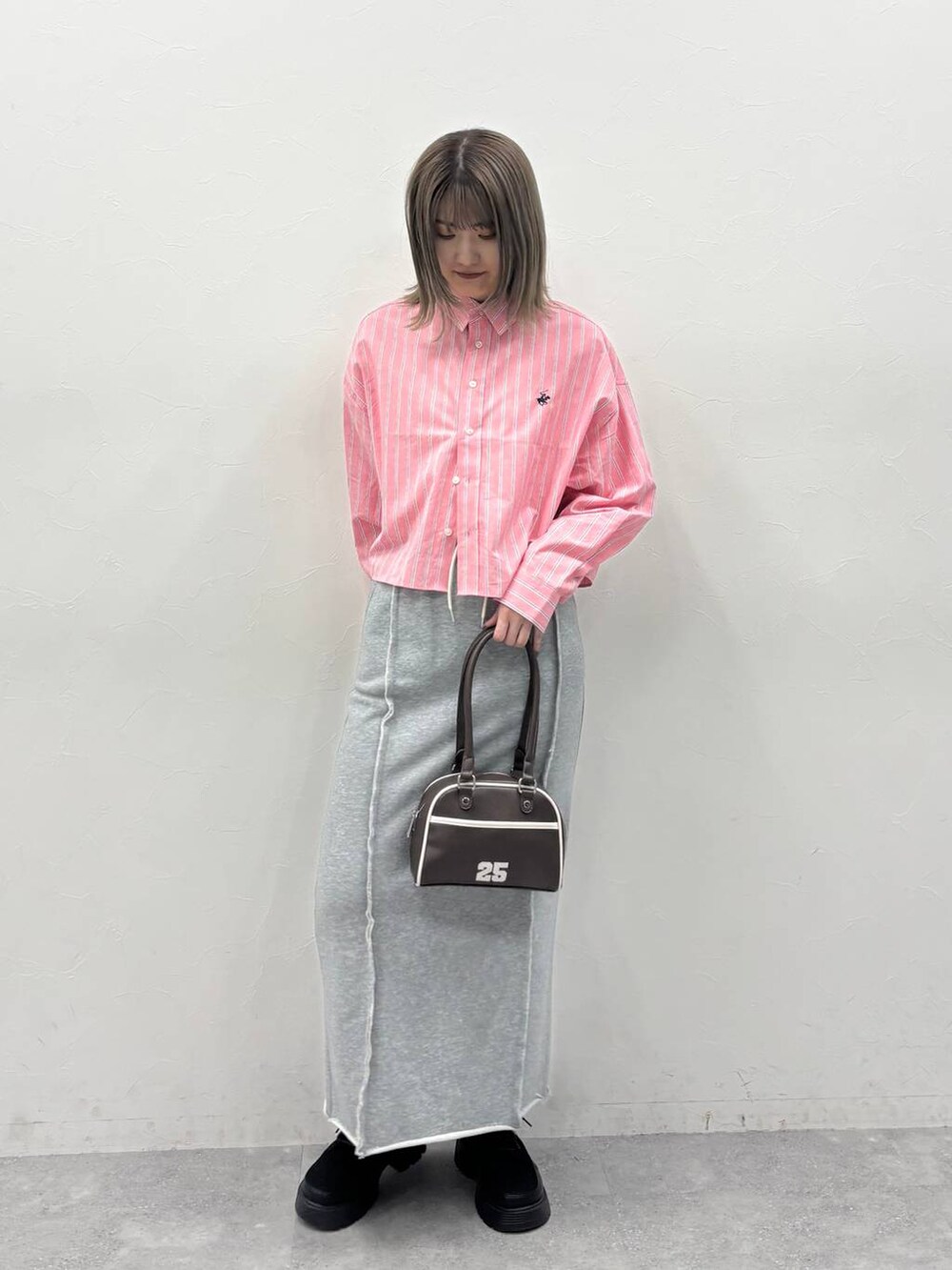 ブラック系のブーツ、レッド系のシャツ/ブラウス、グレー系のスカートを着用したレディースの冬コーディネートの3枚目の写真