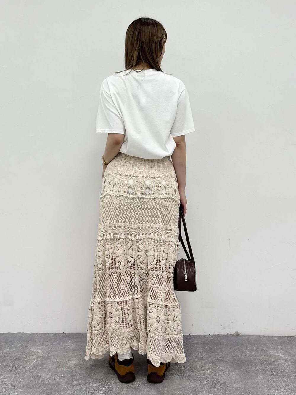 ホワイト系のTシャツ/カットソー、ブラウン系のボストンバッグ、ブラウン系のスニーカーを着用したレディースの春コーディネートの3枚目の写真